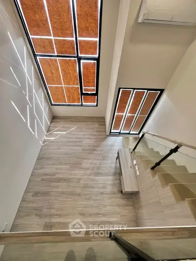 Stunning modern loft with high ceilings and large windows, featuring sleek wooden flooring and contemporary design.