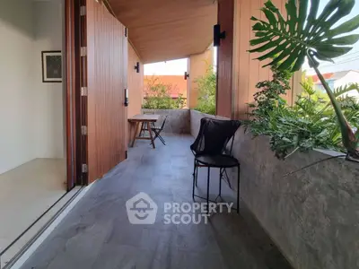 Spacious balcony with modern design and lush greenery, perfect for relaxation.