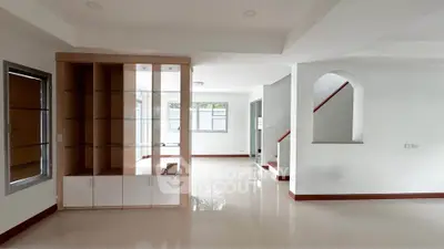 Spacious modern living room with built-in shelving and large windows