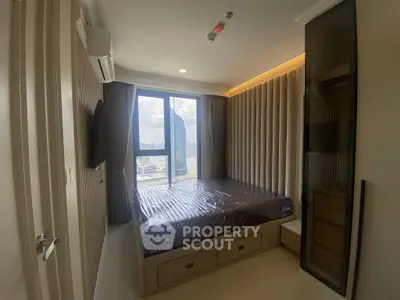 Modern bedroom with large window offering stunning city view, featuring sleek design and ample storage space.