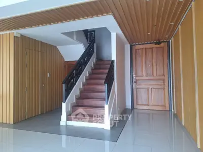 Elegant entrance with wooden staircase and modern design elements