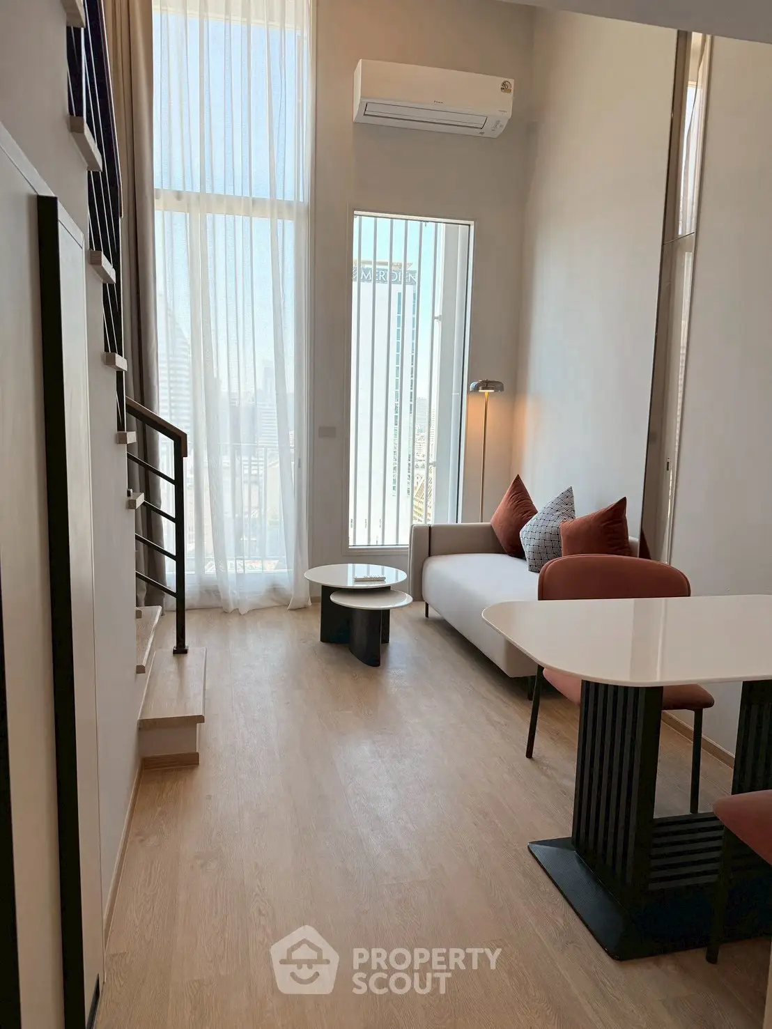 Modern living room with high ceilings and stylish furniture in a bright apartment.