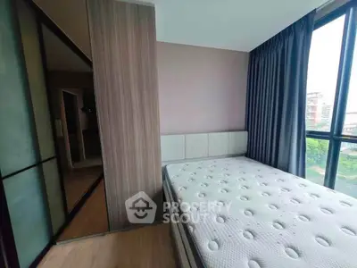 Modern bedroom with large window and stylish wardrobe in a high-rise apartment.