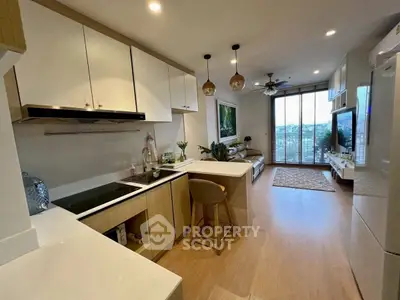 Modern open-layout kitchen and living room with stylish decor and natural light.