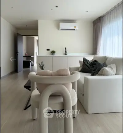 Modern living room with stylish furniture and natural light, featuring a cozy sofa and elegant decor.