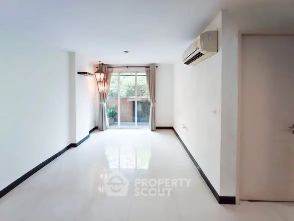 Spacious empty living room with large window and air conditioning