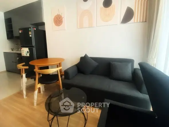 Modern living room with stylish decor and compact kitchen area.