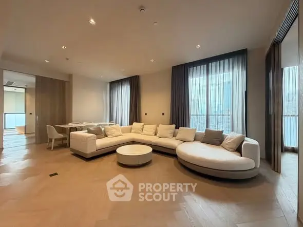 Spacious modern living room with elegant curved sofa and natural light