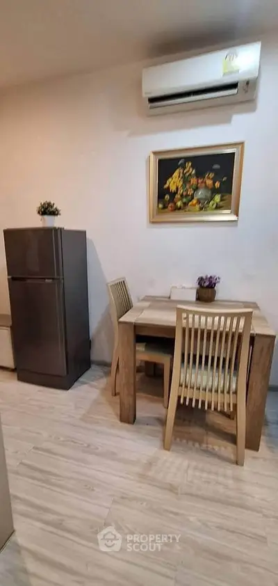 Cozy dining area with modern fridge and air conditioning in stylish apartment.