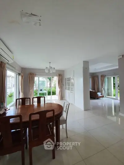 Spacious open-plan living and dining area with large windows and garden view