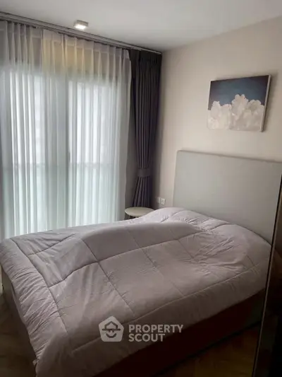 Cozy bedroom with modern decor and large window for natural light
