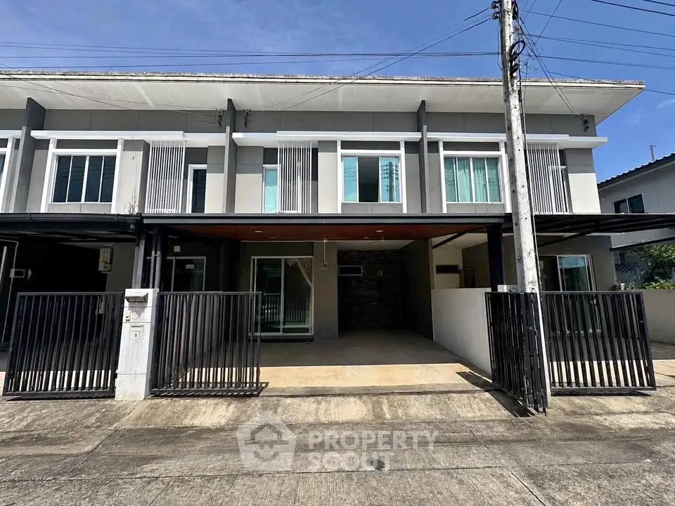 Modern townhouse exterior with sleek design and gated entrance in a suburban neighborhood.