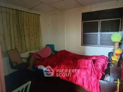 Cozy bedroom with red bedding and natural light from window