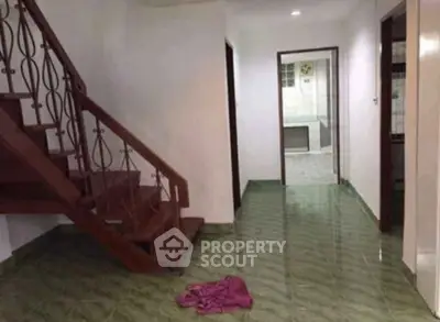 Spacious interior with wooden staircase and tiled flooring, ideal for modern living.