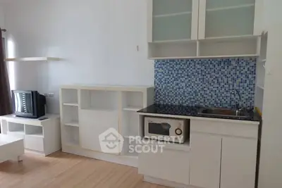 Modern compact kitchen with mosaic backsplash and integrated appliances.