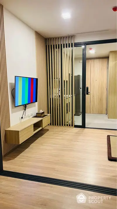 Modern living room with sleek wooden accents and wall-mounted TV in stylish apartment.