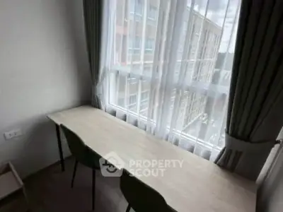 Bright study area with large window and modern desk in urban apartment