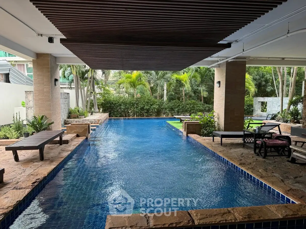 Luxurious indoor pool area with lush greenery and stylish seating, perfect for relaxation and leisure.