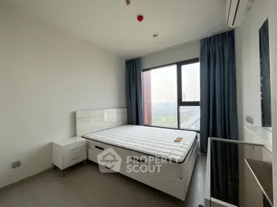 Modern bedroom with city view, featuring sleek design and natural light.