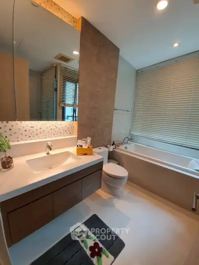 Modern bathroom with sleek design, featuring a bathtub and stylish vanity in a contemporary apartment.