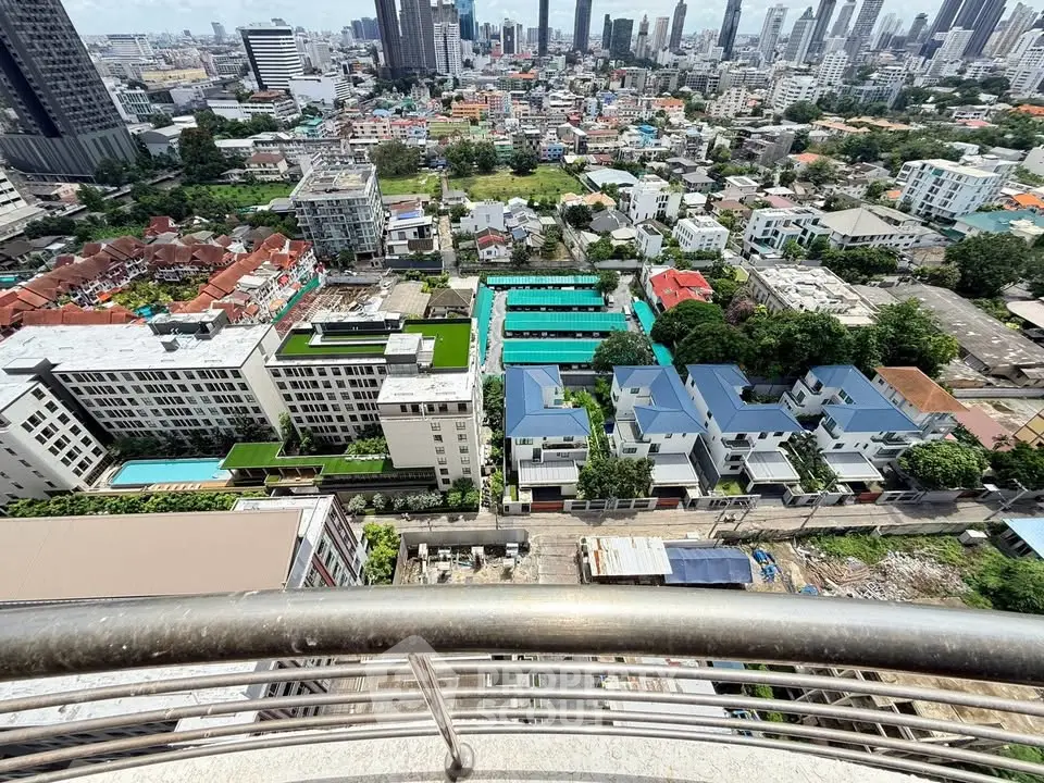 Stunning cityscape view from a high-rise balcony overlooking urban skyline and residential areas.