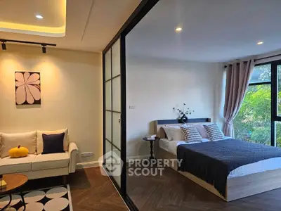 Modern bedroom with stylish decor and large window offering natural light and garden view.
