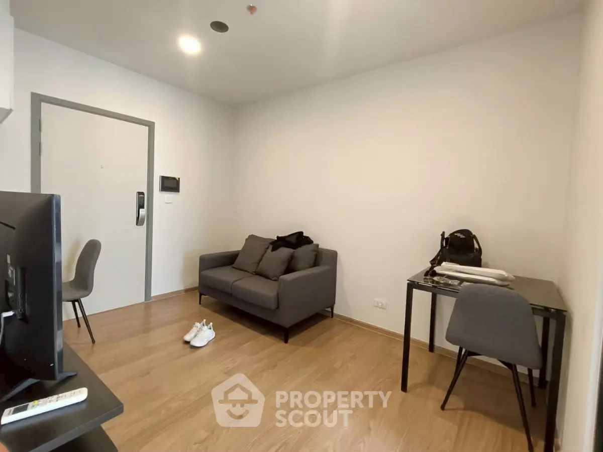 Modern living room with sleek furniture and wooden flooring, perfect for cozy urban living.