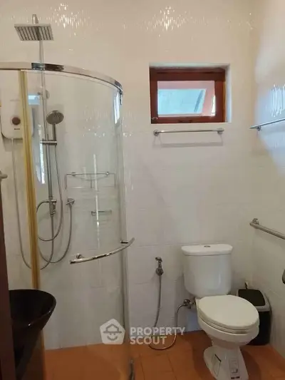 Modern bathroom with glass shower enclosure and sleek fixtures.