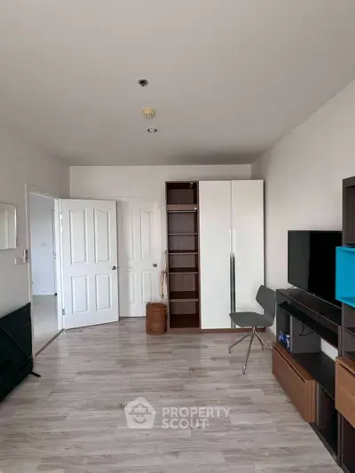 Modern living room with sleek furniture and open layout, featuring a stylish wardrobe and TV unit.