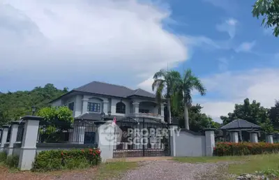 Stunning luxury villa with gated entrance and lush greenery