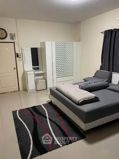 Spacious bedroom with modern decor and cozy ambiance, featuring a stylish bed and wardrobe.