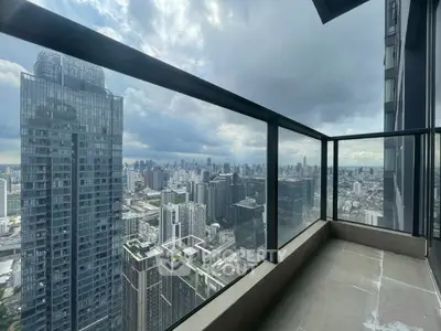 Stunning cityscape view from a high-rise balcony with glass railing.