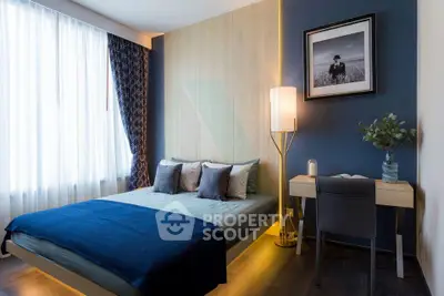 Modern bedroom with stylish decor and natural light, featuring a cozy bed and a sleek desk area.