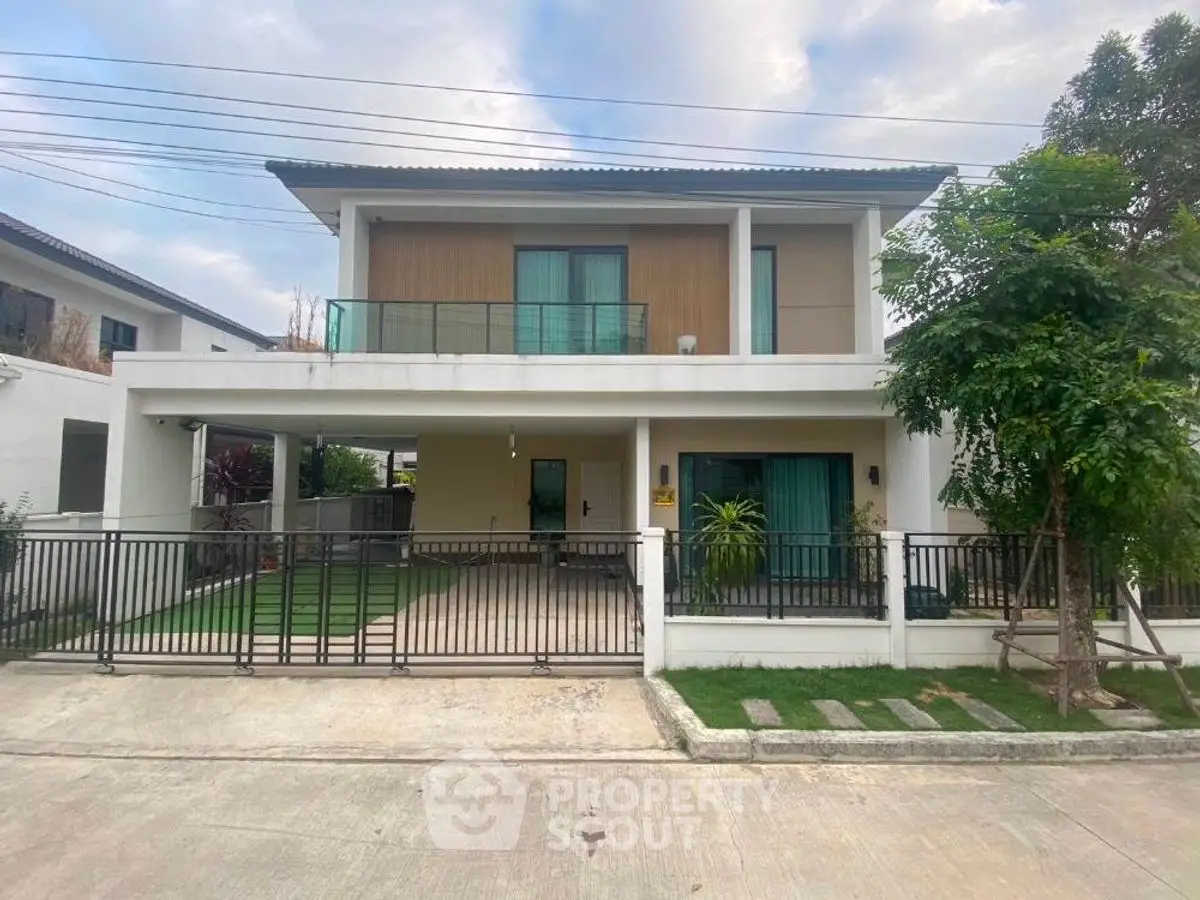 Modern two-story house with spacious driveway and balcony in a suburban neighborhood.
