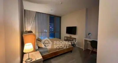 Modern bedroom with cozy lighting and city view, featuring a stylish bed and workspace.