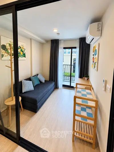 Modern living room with stylish decor and balcony access in a cozy apartment.