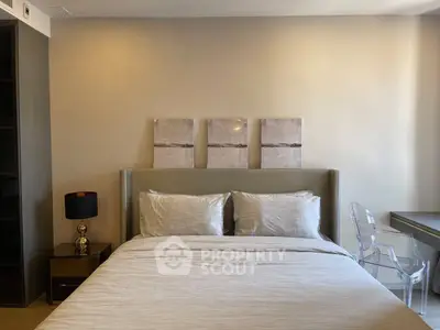 Modern bedroom with elegant decor and cozy bedding in a stylish apartment.