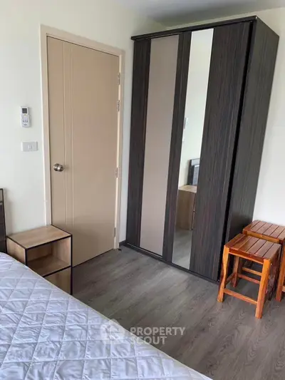 Cozy bedroom with modern wardrobe and wooden flooring, perfect for urban living.