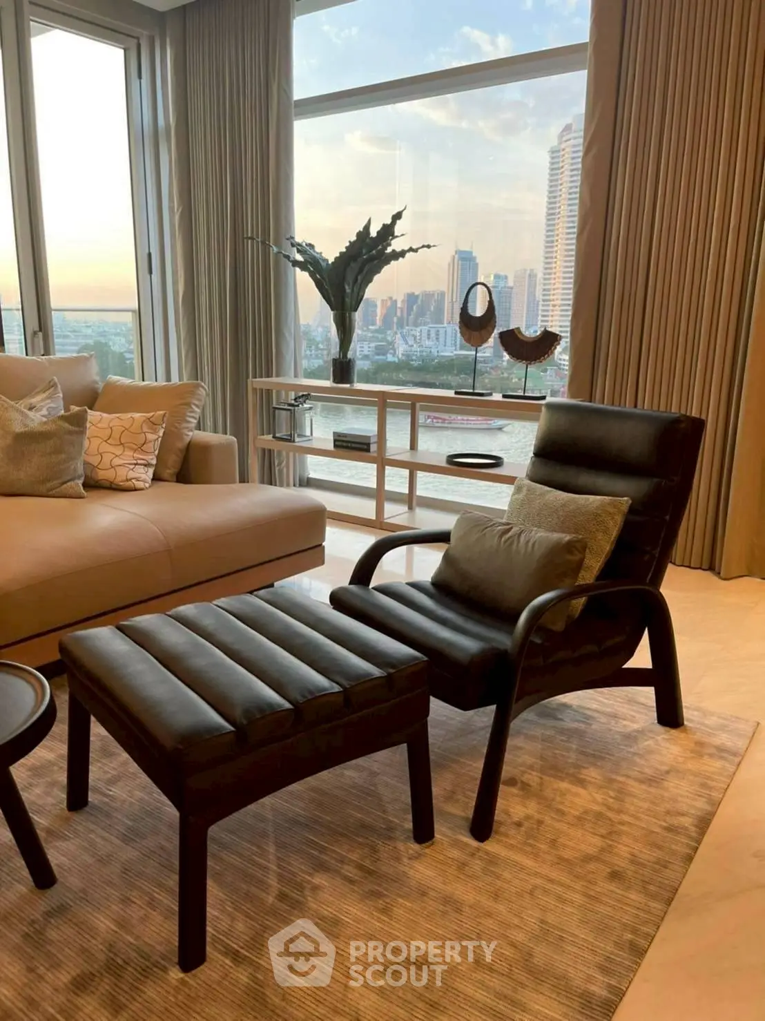 Luxurious living room with stunning city view, elegant furniture, and floor-to-ceiling windows.