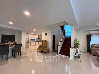 Spacious open-plan living area with modern kitchen and elegant staircase