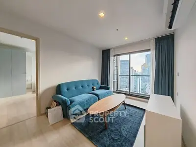 Modern living room with city view, blue sofa, and elegant decor.