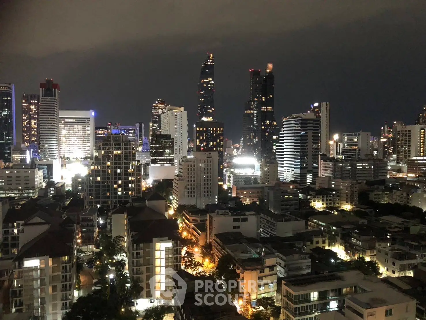 Stunning nighttime cityscape view showcasing illuminated skyscrapers and urban landscape.
