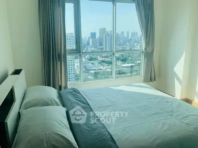 Spacious bedroom with stunning city view and large windows in modern apartment.