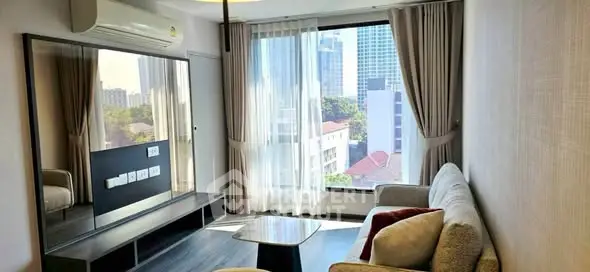 Modern living room with large window and city view, featuring cozy sofa and sleek decor.