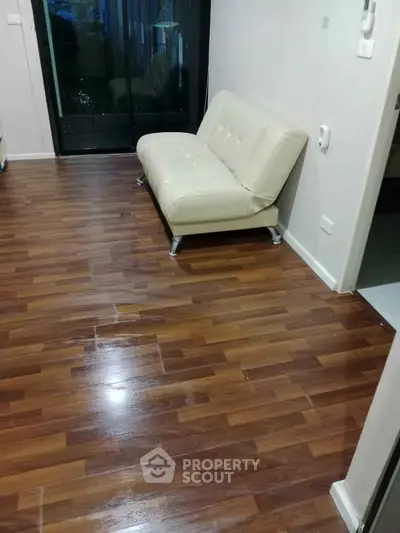 Modern living room with sleek wooden flooring and stylish white sofa.