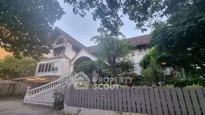 Charming colonial-style house with lush garden and grand staircase entrance