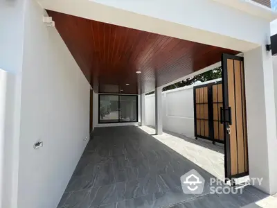 Modern covered parking area with sleek wooden ceiling and stylish gate