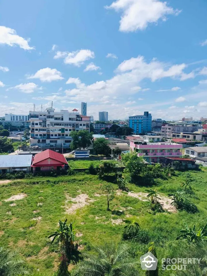 Stunning cityscape view with lush greenery and modern buildings under a clear blue sky.