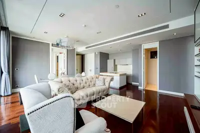 Luxurious modern living room with elegant furniture and open kitchen layout.