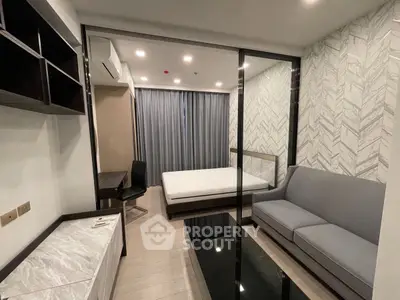 Modern studio apartment with stylish decor and glass partition in urban setting.
